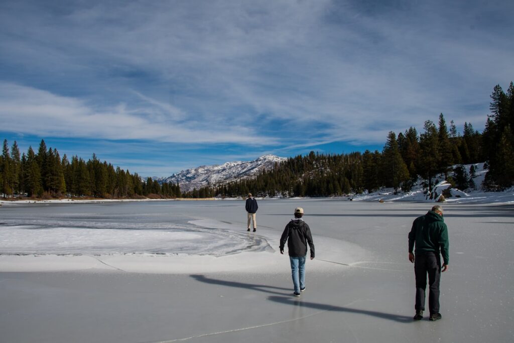 Group snowshoeing on Bear Lake snowshoe trails Rocky Mountain National Park with mountain backdrop