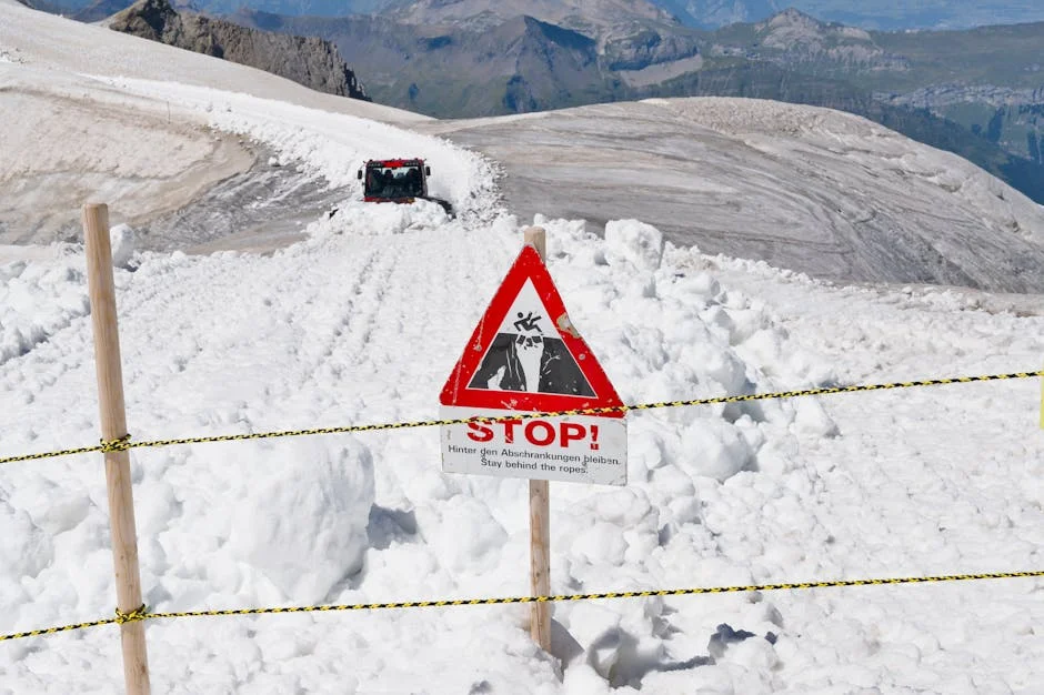 Avalanche warning sign on snowy mountain trail alerting hikers to danger