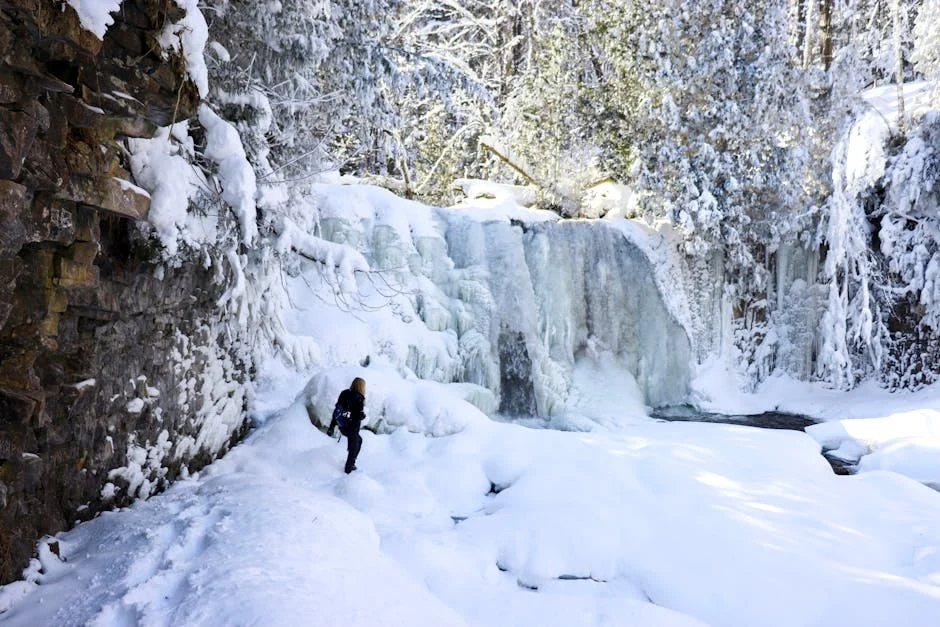 Ricketts Glen Winter Hiking: Frozen Falls Guide (2026) 3 Stunning frozen waterfall cascading down rocky cliff with snow-covered winter trail
