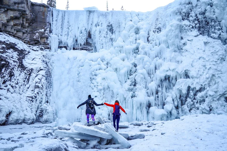 Ricketts Glen Winter Hiking: Frozen Falls Guide (2026) 5 Two adventurers exploring the base of a massive icy waterfall in winter conditions