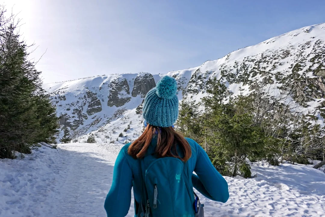 Ricketts Glen Winter Hiking: Frozen Falls Guide (2026) 6 Woman in winter hiking gear with crampons and ice axe standing on snowy trail