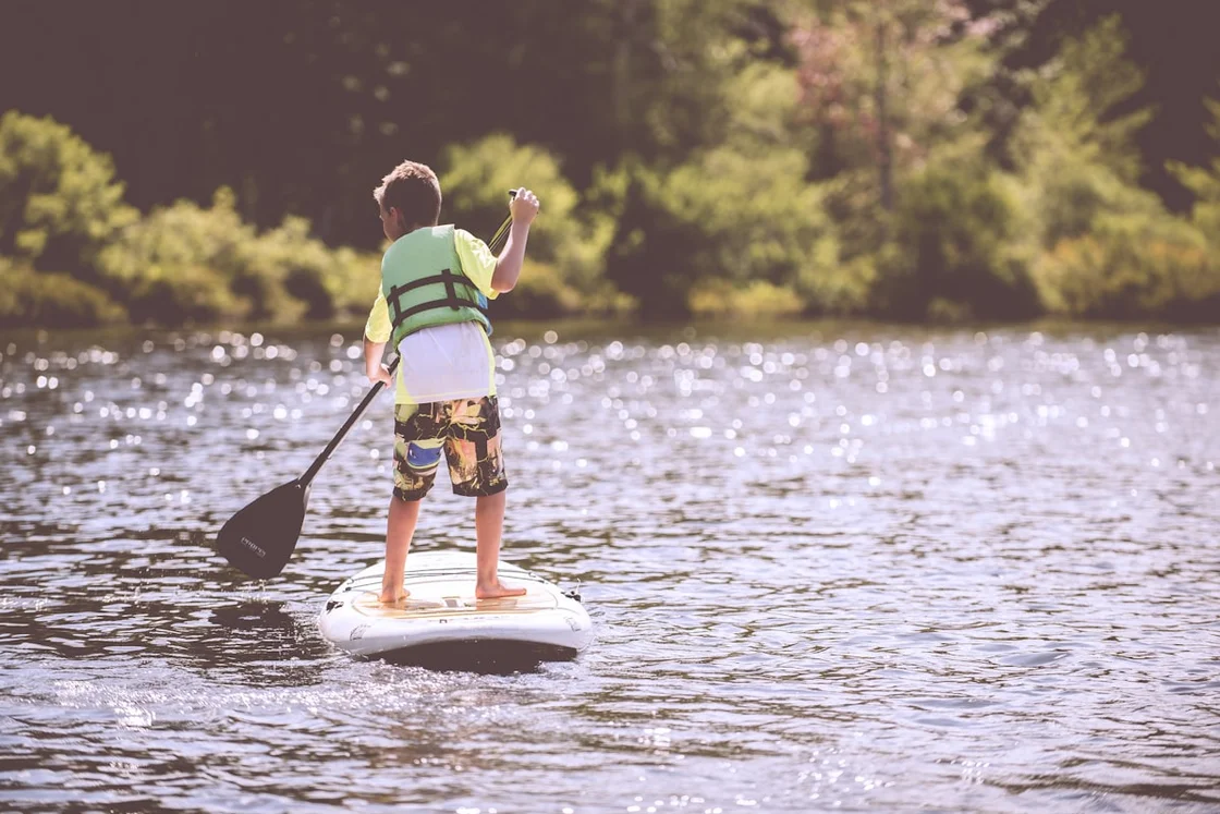 Kayaker paddling on peaceful calm water surrounded by nature