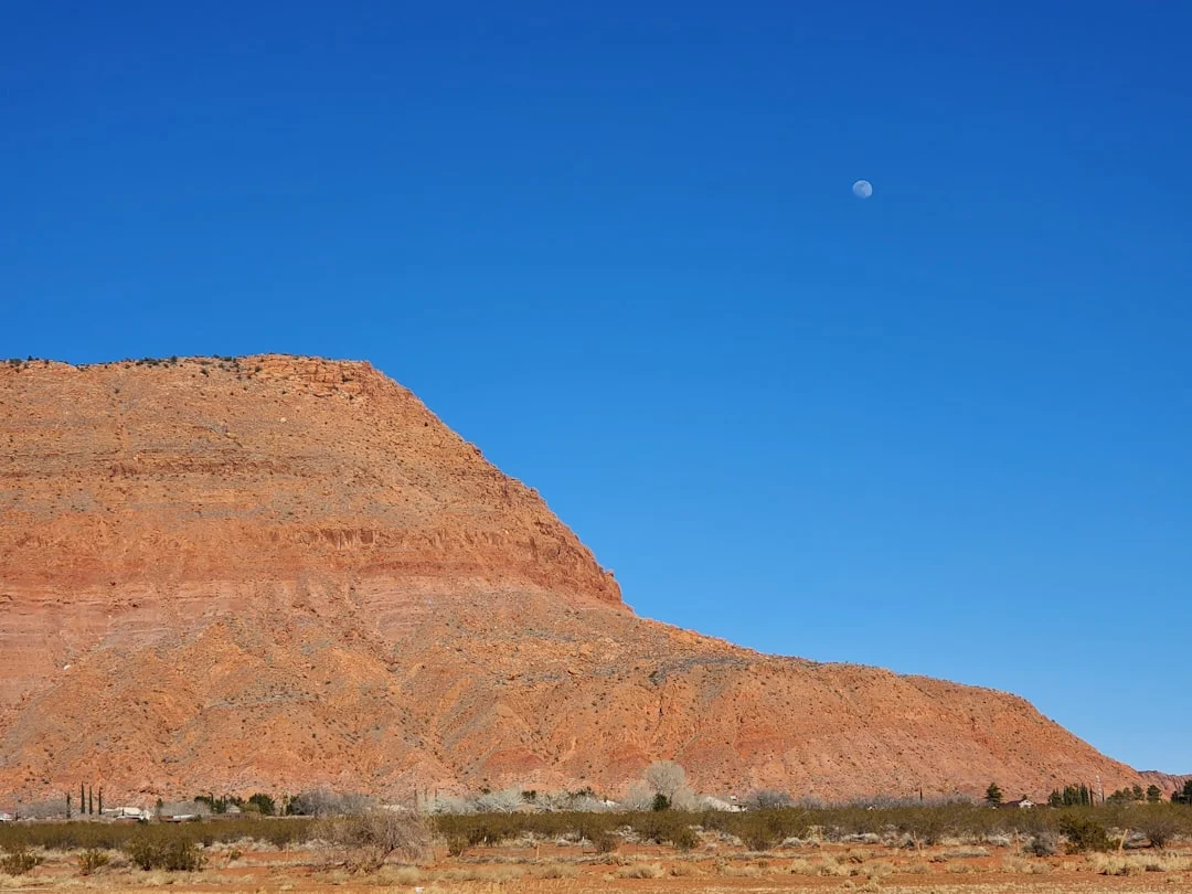 Dramatic moon rising over mountain silhouette at dusk