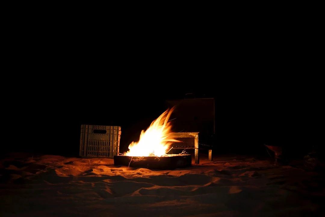 Campfire in winter snow outdoor night scene providing warmth