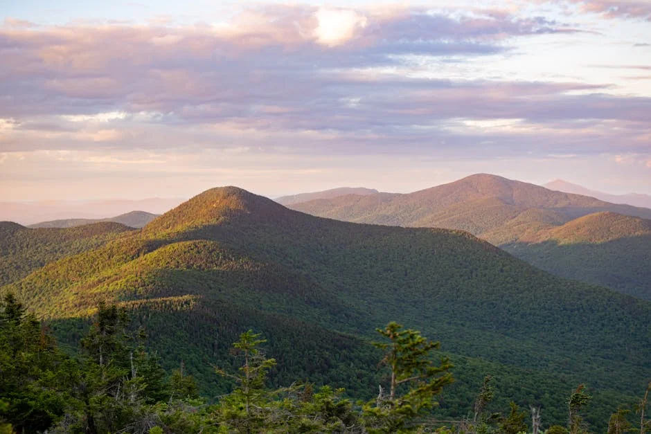 Explore the serene beauty of Vermont's green mountains during sunrise with dramatic clouds