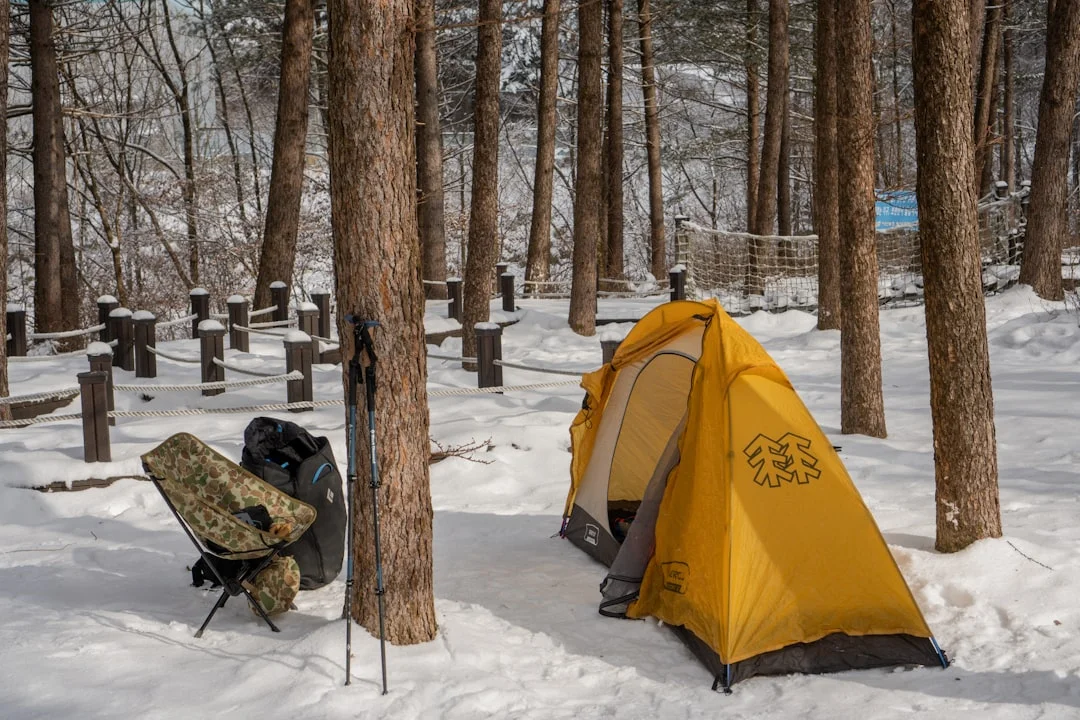 Winter camping gear and backpack partially buried in fresh snow